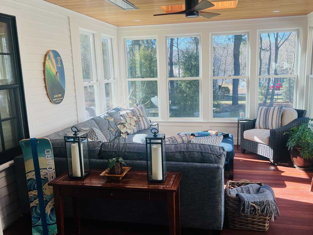 Enclosed sunny porch with surfboards designed arranged by Collen Van Houten